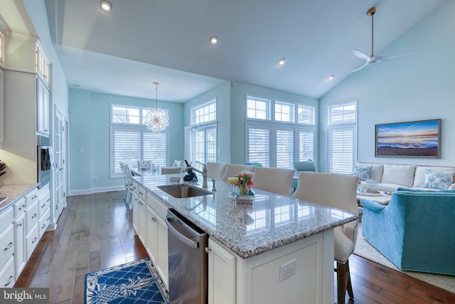 kitchen featuring a kitchen island with sink, a sink, open floor plan, dark wood finished floors, and stainless steel appliances