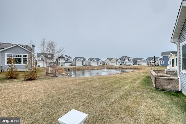 view of yard featuring a residential view and a water view