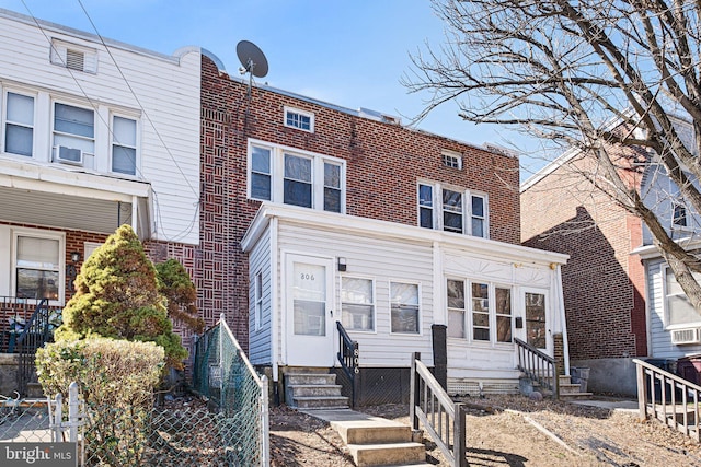 multi unit property with entry steps, fence, and brick siding