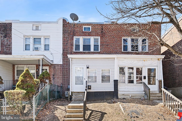 townhome / multi-family property featuring entry steps and brick siding