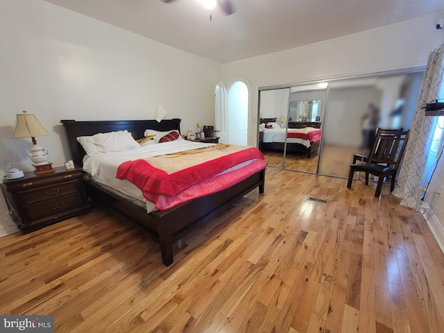 bedroom with a closet, light wood finished floors, and ceiling fan