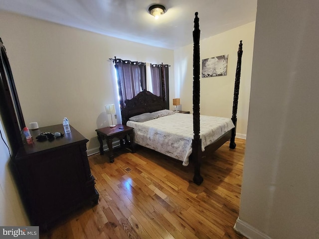 bedroom with baseboards and hardwood / wood-style flooring