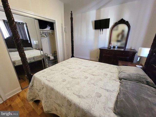 bedroom featuring a closet, baseboards, and wood finished floors