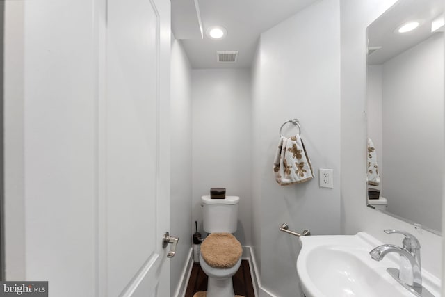 bathroom featuring a sink, visible vents, toilet, and recessed lighting