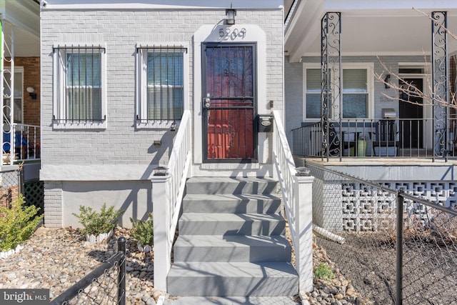 property entrance featuring brick siding and covered porch