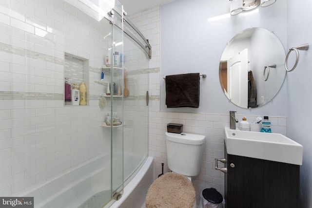 bathroom with vanity, toilet, and bath / shower combo with glass door