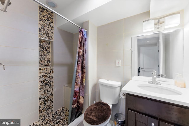 full bathroom with toilet, tile walls, a stall shower, and vanity