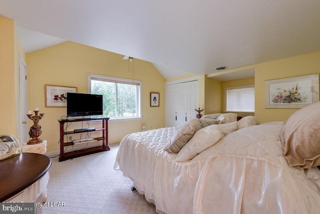 bedroom featuring light carpet, visible vents, and vaulted ceiling