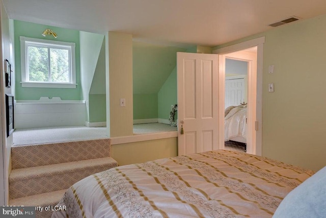 carpeted bedroom featuring visible vents