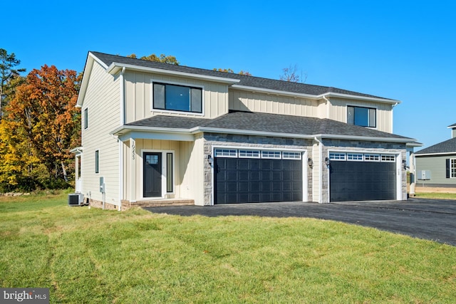 view of front of property featuring board and batten siding, a front lawn, aphalt driveway, central AC, and an attached garage