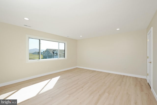 empty room with visible vents, recessed lighting, light wood-style floors, and baseboards