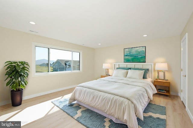 bedroom with recessed lighting, light wood-style floors, visible vents, and baseboards