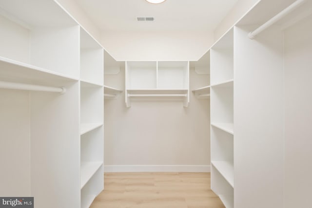 spacious closet featuring visible vents and wood finished floors