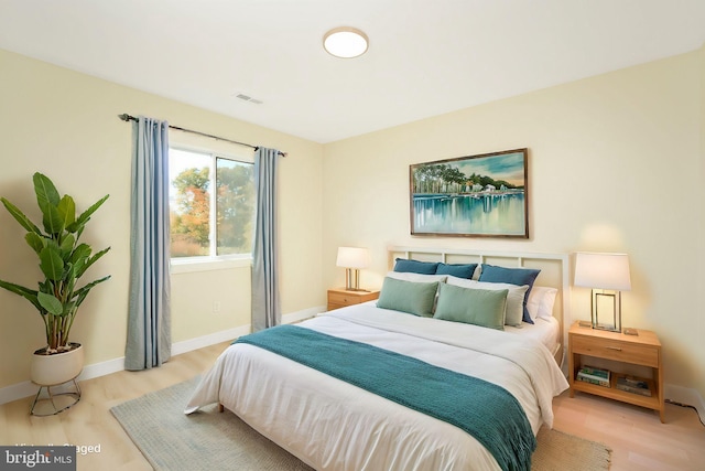 bedroom featuring visible vents, baseboards, and light wood-style flooring