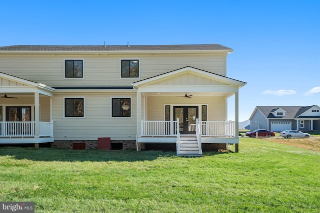 rear view of house with french doors, a lawn, board and batten siding, and a ceiling fan