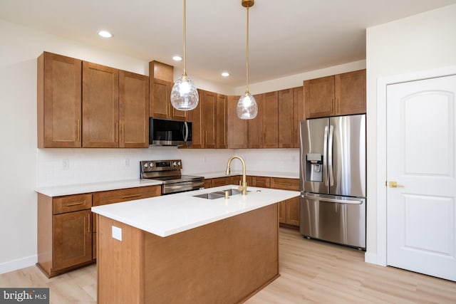 kitchen with brown cabinets, a sink, backsplash, stainless steel appliances, and light wood finished floors