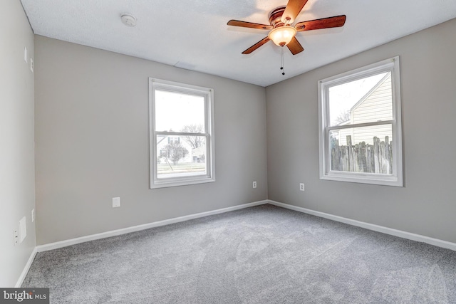 empty room featuring ceiling fan, baseboards, and carpet floors