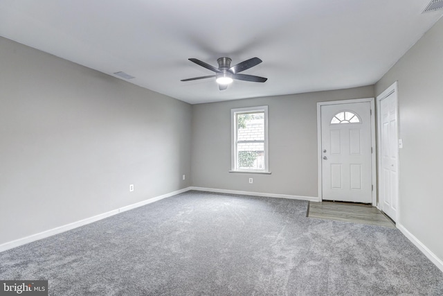 carpeted foyer with a ceiling fan, baseboards, and visible vents