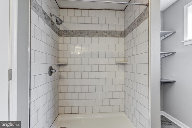 bathroom with a stall shower and baseboards