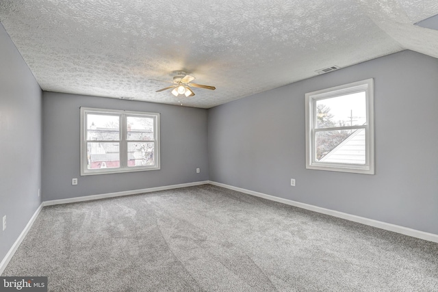 spare room with carpet flooring, ceiling fan, a textured ceiling, and baseboards