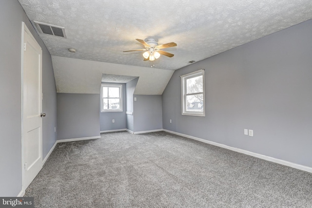 bonus room featuring visible vents, carpet flooring, a textured ceiling, and baseboards