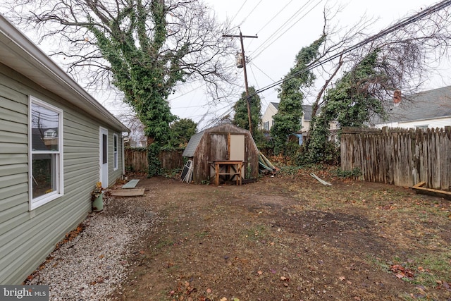 view of yard with an outbuilding, a fenced backyard, and a storage shed