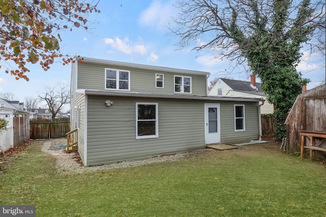 back of property featuring a lawn and a fenced backyard