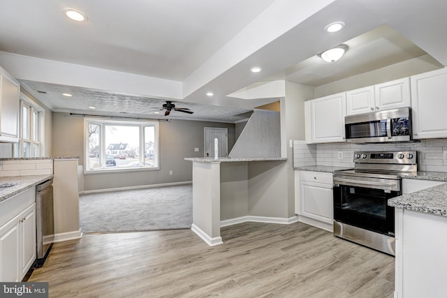 kitchen featuring backsplash, white cabinets, and appliances with stainless steel finishes