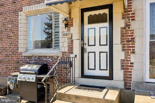 doorway to property with brick siding