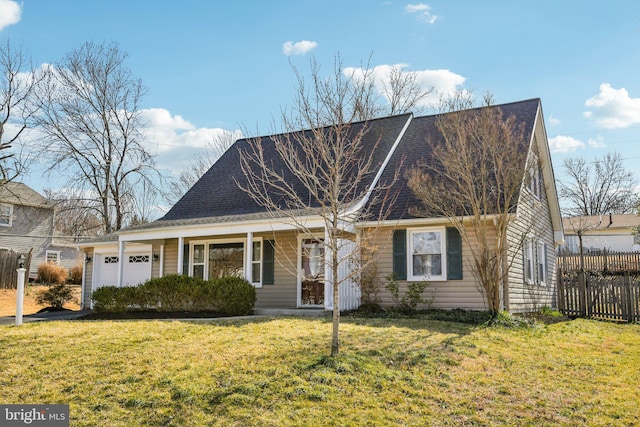 view of front facade with a front yard, an attached garage, and fence