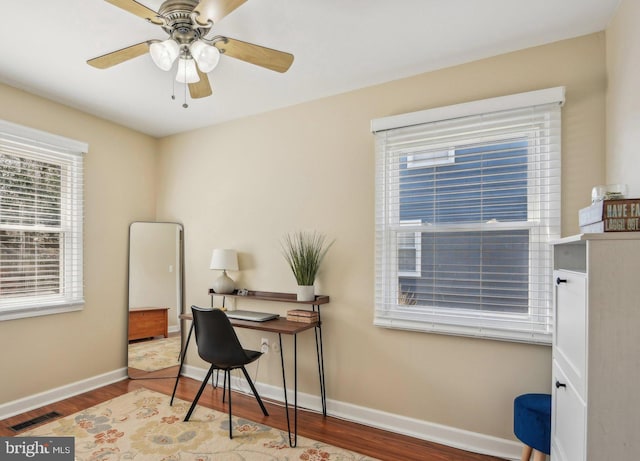 office area with wood finished floors, visible vents, baseboards, and ceiling fan