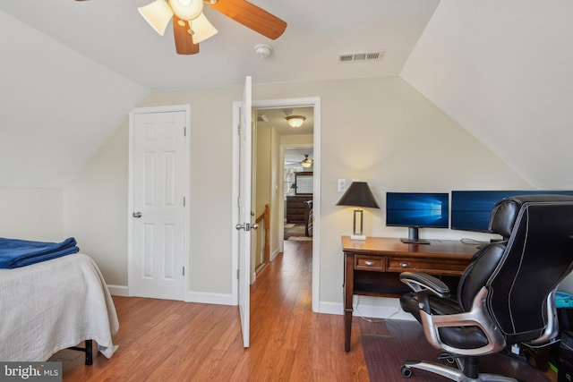 interior space featuring visible vents, a ceiling fan, wood finished floors, baseboards, and lofted ceiling