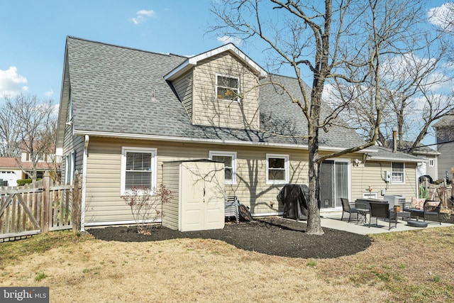 back of house with a patio area, a lawn, a shingled roof, and fence