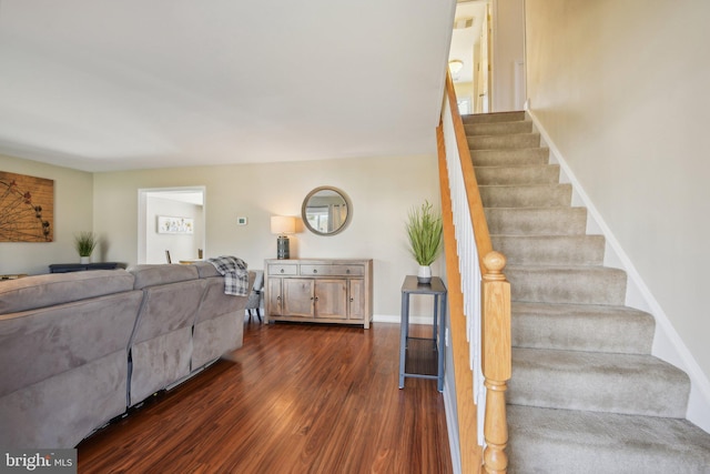 staircase featuring baseboards and wood finished floors