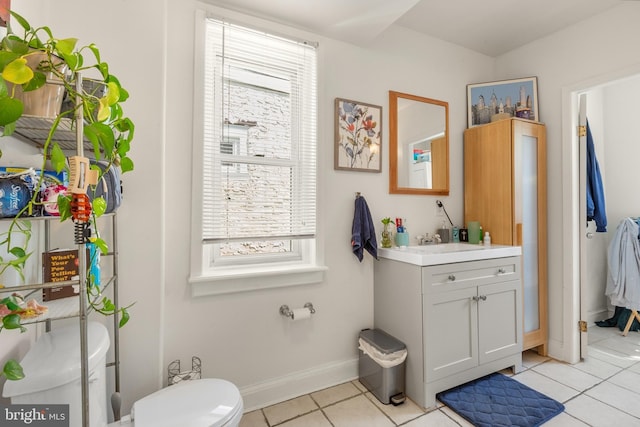 bathroom featuring toilet, vanity, baseboards, and tile patterned flooring