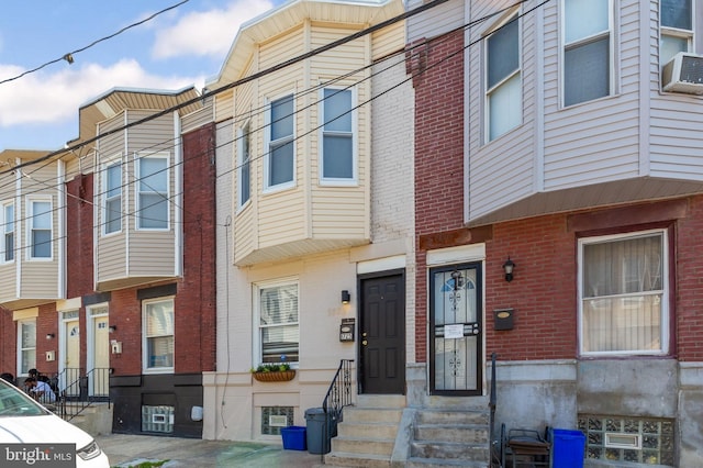 multi unit property with brick siding, entry steps, and cooling unit