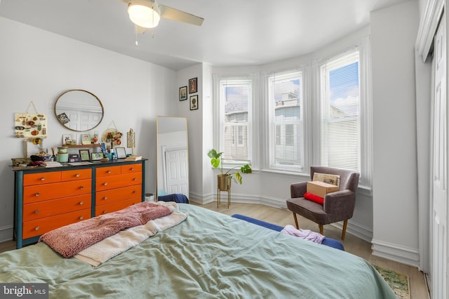 bedroom featuring multiple windows, baseboards, and wood finished floors