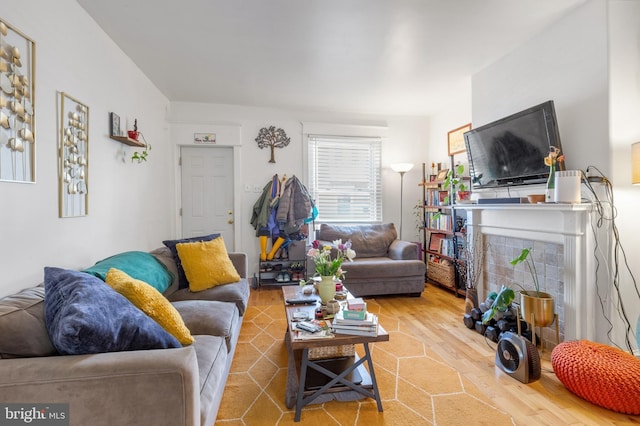 living room featuring wood finished floors and a tile fireplace