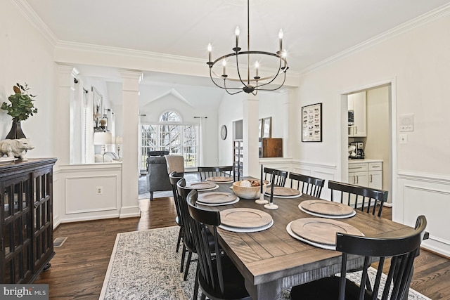 dining room with a wainscoted wall, ornamental molding, dark wood-style floors, an inviting chandelier, and a decorative wall