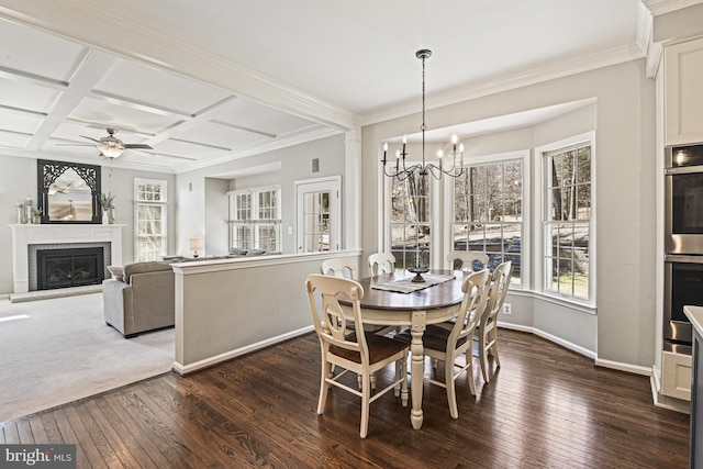 dining area with dark wood-type flooring, ceiling fan with notable chandelier, coffered ceiling, a fireplace, and baseboards