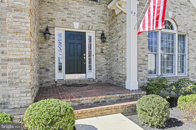 doorway to property featuring brick siding