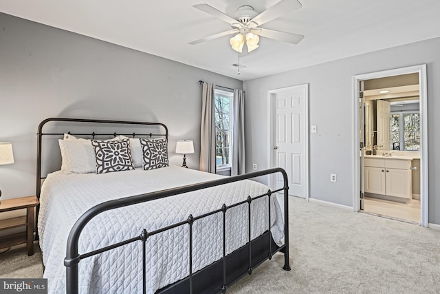 carpeted bedroom with baseboards, ceiling fan, and ensuite bathroom