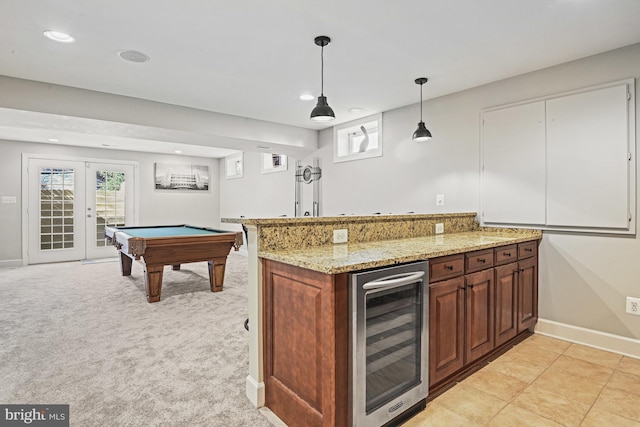 kitchen with light stone counters, recessed lighting, wine cooler, light colored carpet, and hanging light fixtures