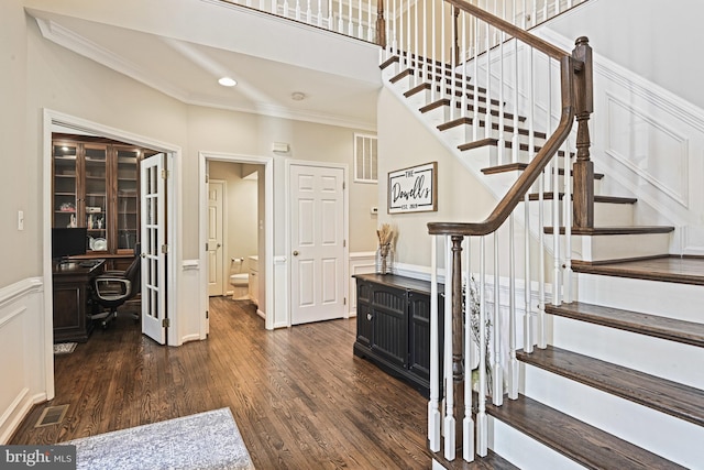 stairway featuring crown molding, wood finished floors, and visible vents