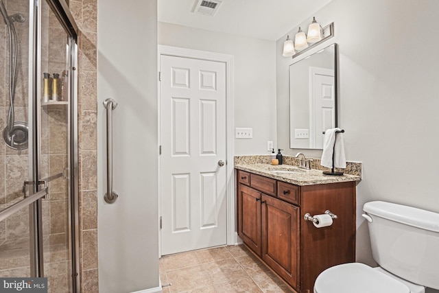 full bathroom featuring vanity, a shower stall, toilet, and visible vents