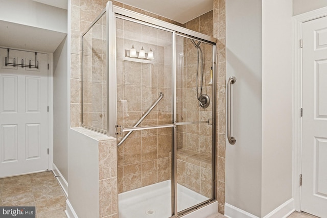 full bathroom featuring baseboards and a shower stall