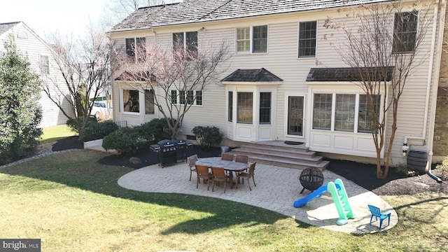 rear view of property featuring a yard and a patio area