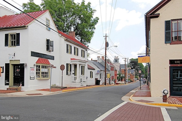 view of street with sidewalks, curbs, and street lighting