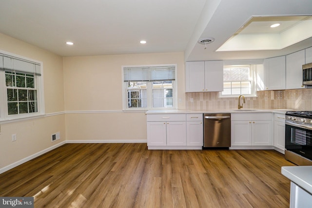 kitchen featuring tasteful backsplash, visible vents, stainless steel appliances, and a sink