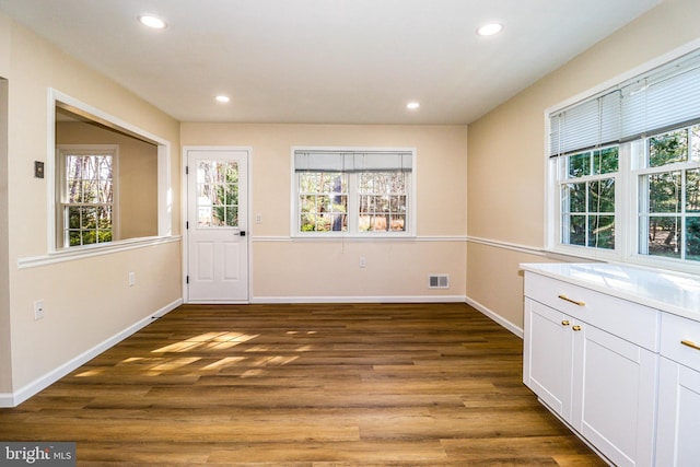 unfurnished dining area featuring recessed lighting, visible vents, and wood finished floors